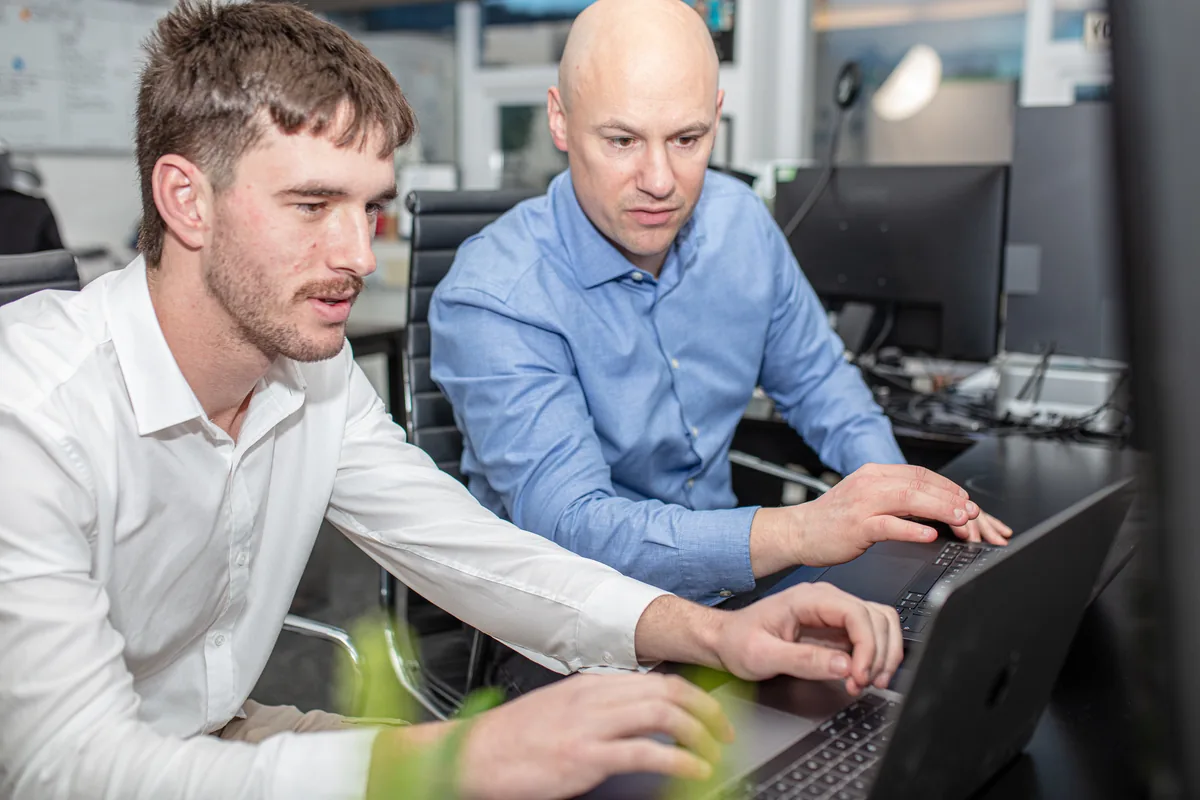 David and Luke from Halizona reviewing a client site together on a laptop