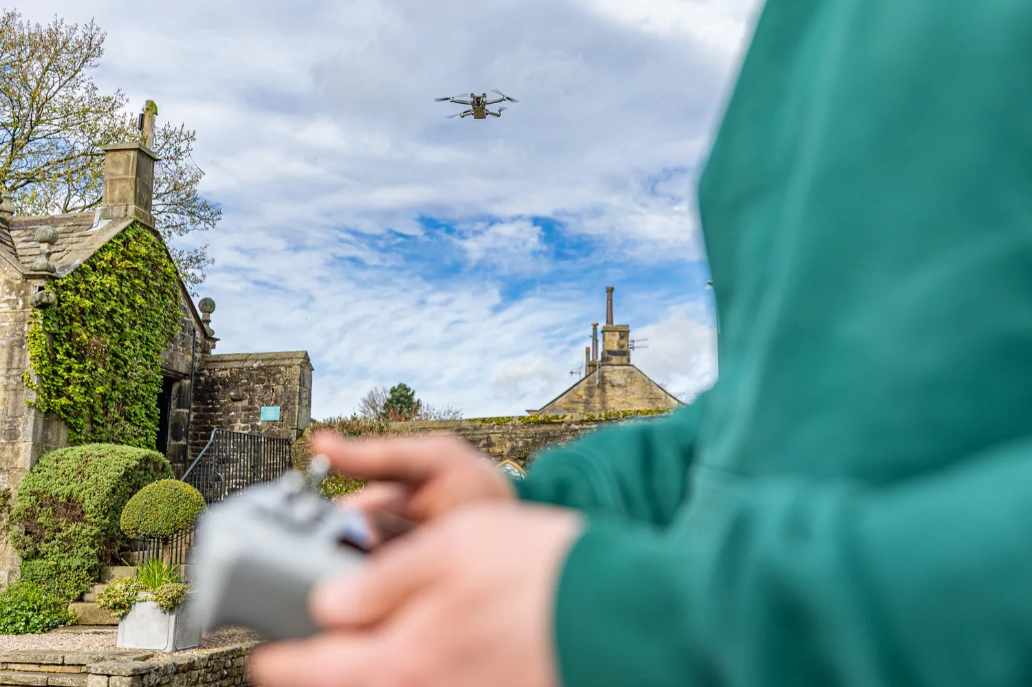 Halizona flying the drone above a stone building on a client shoot